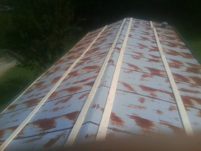 Rusted metal roof panels with new wood purlins before replacement — Storm Damage Roof Repair in Elliston by Roofing Brothers