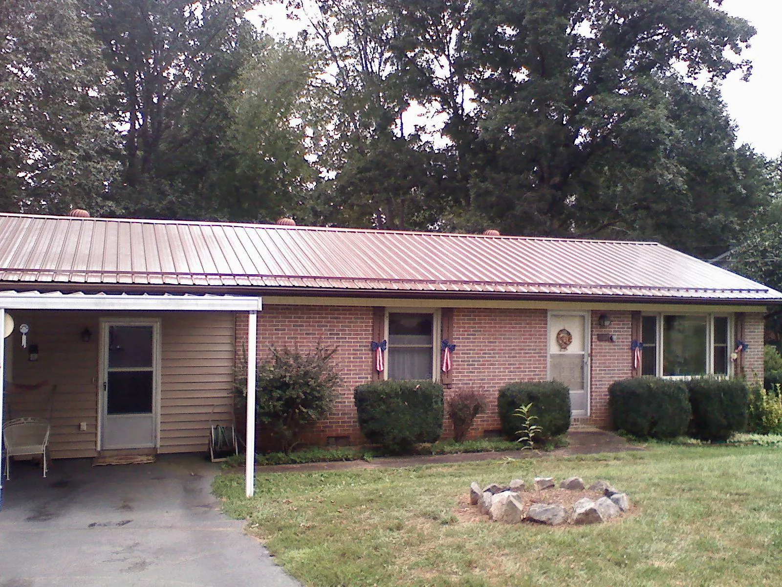 Bronze metal roof and carport on a brick ranch home — Roof Repair work by our crew in Elliston